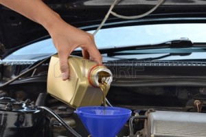 22184832-car-servicing-mechanic-pouring-oil-to-engine